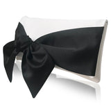 Black bow on an ivory clutch handbag