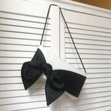 Ivory satin handbag with black bow for brides on wedding day