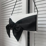 Ivory shoulder evening bag with a black bow