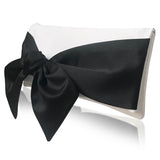 Black bow on an ivory clutch handbag